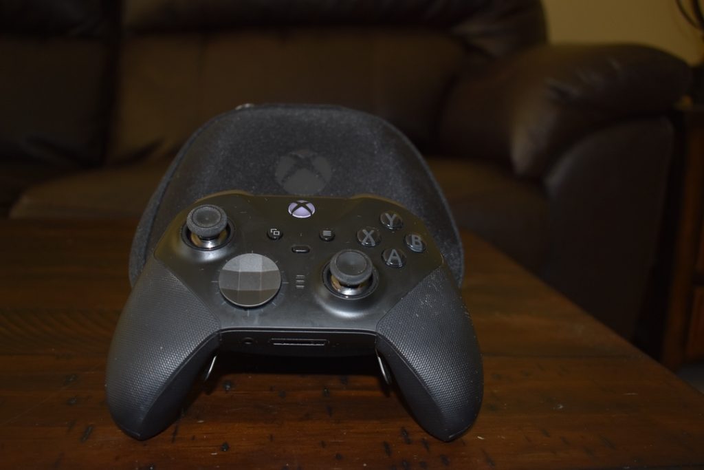 XBOX ONE elite controller series 2 with case on wood table, propped up 